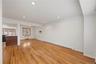 Recessed ceiling lighting, wood-finish flooring, and a built-in breakfast bar with a dark countertop