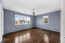 Dark wood-finish flooring with a prominent bay window