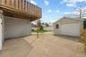 Exterior concrete patio with an overhead wood-plank deck