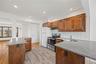 Kitchen featuring wood cabinetry, light-colored countertops, stainless steel appliances, and a tiled backsplash