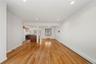 Wood-finish flooring throughout, recessed ceiling lighting, and a kitchen with wood cabinetry and a white refrigerator