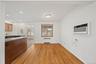 Hardwood flooring, recessed lighting, kitchen peninsula with granite countertop, wood cabinetry, and a wall-mounted air conditioning unit