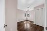 Hardwood flooring with a corner window, bi-fold closet doors, and a ceiling-mounted light fixture