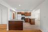 Kitchen featuring wood cabinetry, stainless steel range, white subway tile backsplash, and light-toned wood-finish flooring