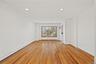 Hardwood flooring, recessed ceiling lighting, and large picture windows with wood trim