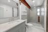 Stunning primary bathroom features original beam