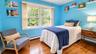 The spacious third bedroom features bookshelves and an abundance of natural light, creating a bright and inviting space ideal for a bedroom and home s