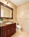 A stylish first-floor powder room features beautiful coordinating floor and wall tile, adding a touch of elegance and sophistication.