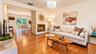 This inviting family room is anchored by a stunning double-sided wood-burning fireplace and an elegant chandelier, creating a warm and sophisticated s