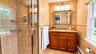 The luxurious primary en-suite bath features a walk-in shower with a custom glass enclosure and beautifully appointed tilework, creating a spa-like re
