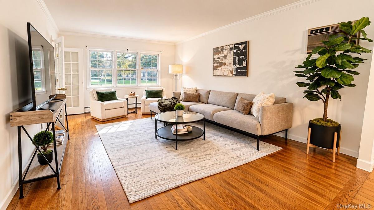 Another stunning view of this expansive living room, highlighted by a wall of windows that fills the space with abundant natural light and creates a b