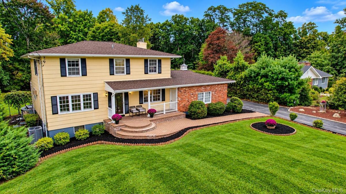 This spectacular home is beautifully complemented by lush landscaping, mature plantings, and an expansive front yard, creating a warm and inviting fir