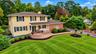 This spectacular home is beautifully complemented by lush landscaping, mature plantings, and an expansive front yard, creating a warm and inviting fir