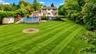 The expansive backyard is a true oasis, offering plenty of room for kids and pets to roam, play, and enjoy the outdoors. With generous open space and 