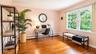 Another beautiful view of this inviting fourth bedroom, featuring double windows that fill the space with natural light, custom built-ins, and a gener