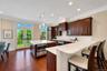 Eat-in chef's kitchen with Wolf induction over&cooktop, SubZero refrigerator, marble counters and island, floor to ceiling windows, and breakfast nook