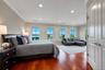 Sprawling primary en suite with river views & automatic Hunter Douglas blinds.