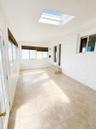 Recessed ceiling skylight, light-toned tile flooring, and multiple windows