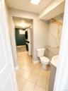 Tile flooring, integrated sink, stacked washer and dryer, and feature wall with gold-veined marble-look paneling