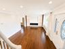Hardwood-finish flooring throughout, recessed ceiling lighting, built-in shelving with integrated lighting, and a linear electric fireplace