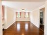Polished wood-finish flooring, crown molding, and two windows with light-filtering treatments