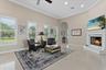 The family room is surrounded by windows with plantation shutters as well as sliders leading to the pool deck