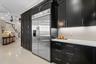 High end stainless steel appliances and a bank of custom cabinets are shown.  There is also a walk-in pantry and two other closets accessible to the k