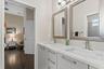 A Jack and Jill bathroom connects bedrooms three and fout, offering dual sinks and mirrors