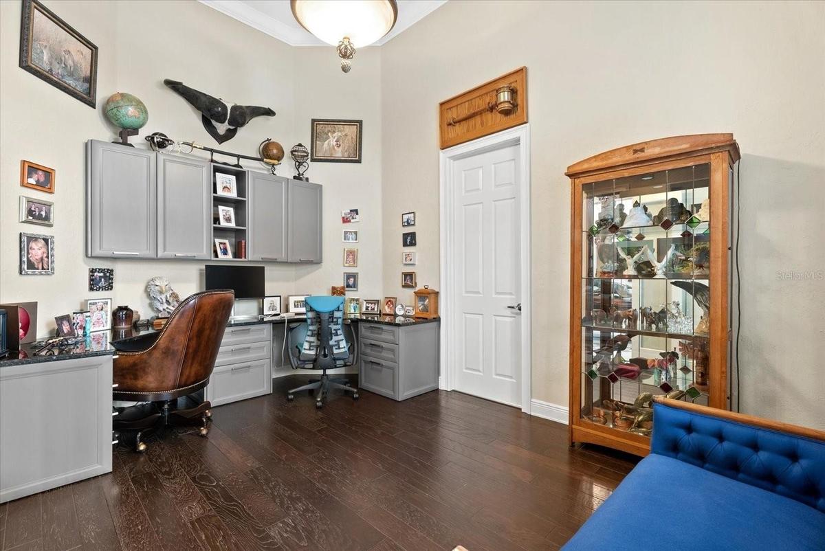 Located immediately to the right of the front entry lobby, you'll find a private office with wood floors, custome built-ins and entry to the hall lead