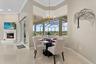 The breakfast nook is surrounded by aquarium glass windows looking out on the pool deck and pastures