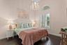 Also on the first floor is a spacious second bedroom with arched window and hardwood floors