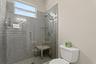 The toilet and shower area are closed off from the shared sink area of the Jack and Jill bathroom upstairs