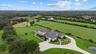 This drone shot shows the main house, front pasture behind the home and a triangle shaped pasture beyond it.