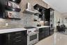 The home offers a gas range/cooktop, built-in oven and microwave with marble countertops