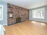 1st floor: Primary bedroom with wood burning fireplace on brick wall with 3 stone shelves.