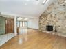 Entry opens to vaulted ceiling in living room with stone wood burning fireplace