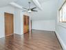 2nd floor: Bedroom #3 showing vinyl flooring , beams & closet.