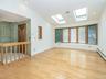 Extended living room with skylights and front bay window with storage.
