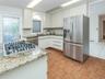 Kitchen has an island that holds the gas cooktop. Granite counter tops.