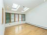Extended living room with skylights and front bay window with storage.