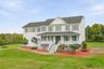 Timeless Colonial charm framed by mature landscaping and a full-length covered porch.