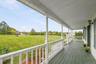 This full-length covered porch is built for coffee in the morning and quiet evenings overlooking the property.
