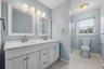 The private en suite features a double vanity and a crisp, updated look.