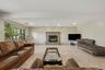 Stone-faced fireplace with hearth, tile flooring, recessed lighting, and large windows
