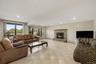 Spacious recreation room featuring tile flooring, a stone-clad fireplace, and recessed lighting