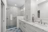 Completely remodeled primary bath w/walk in shower, custom dual vanities and beautiful tile work