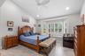 Spacious primary suite with windows overlooking pool, spa and backyard