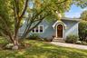 Classic Tudor-Revival hooded front entrance with arched oak door.