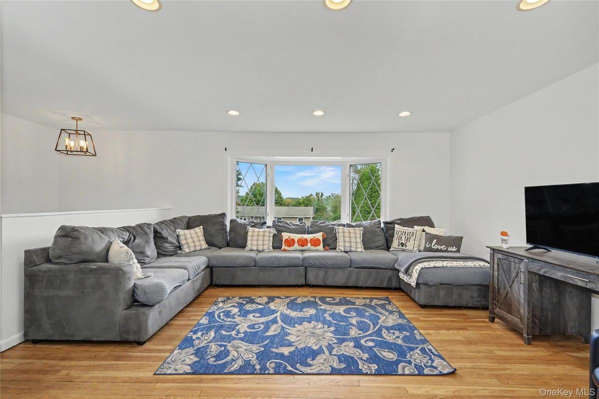 Spacious living room with a large bay window for great natural light and wood flooring