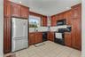 Well equipped and ample kitchen featuring wood cabinetry, recessed lighting, tile flooring and pantry